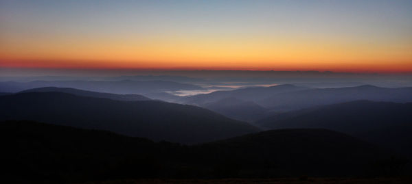 Scenic view of silhouette mountains against sky during sunset