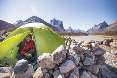 Portrait of climber in his tent at summit lake, akshayak pass