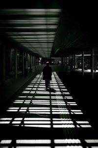 Rear view of silhouette man walking on corridor