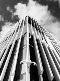 Low angle view of modern building against cloudy sky