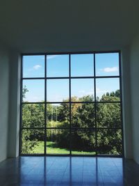 Trees seen through glass window of house