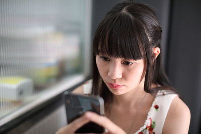 Woman using mobile phone indoors