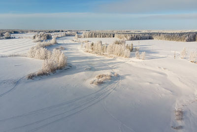 The snow on the river ice is decorated with snow mobile tracks. 
