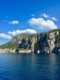 Scenic view of sea and mountains against blue sky