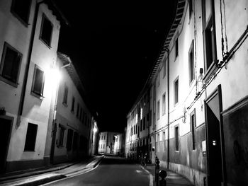 Street amidst buildings in city at night