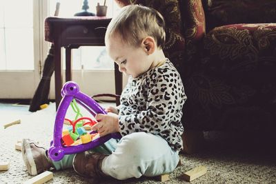 Cute girl playing with toy at home