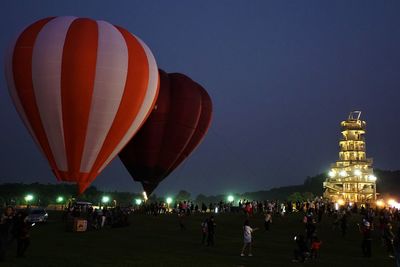 People at illuminated place against clear sky at night