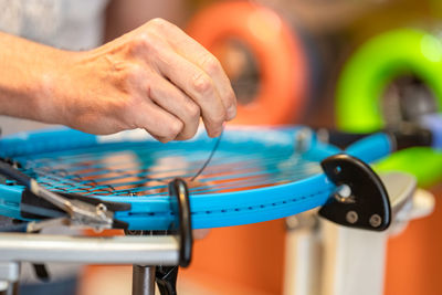 Hand of man making tennis racket