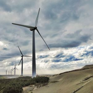 Windmill on field against sky