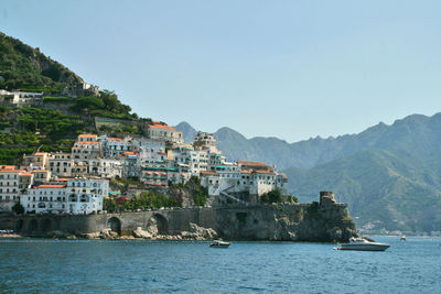 Scenic view of sea by buildings against sky