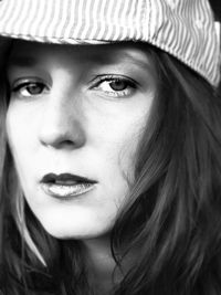 Close-up portrait of young woman wearing flat cap