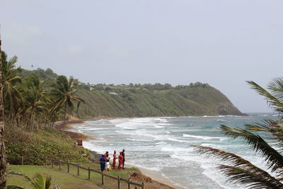 People at beach against sky