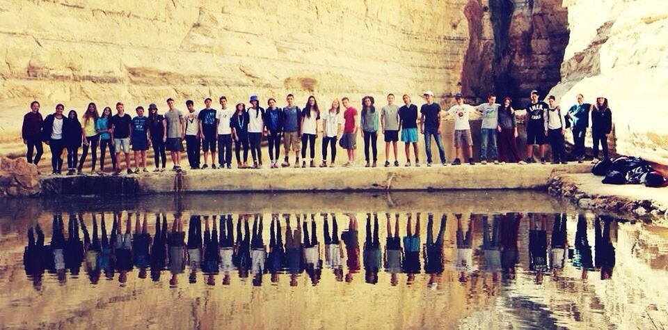 water, men, large group of people, person, sea, beach, in a row, built structure, day, lifestyles, medium group of people, walking, reflection, standing, outdoors, side by side, tourist, leisure activity, architecture