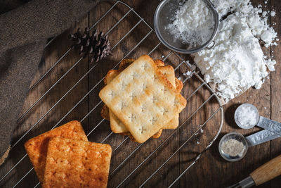 Square dry crackers biscuit on a wooden table. wooden texture dark background. snack dry biscuits