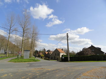 Houses by road against sky in city