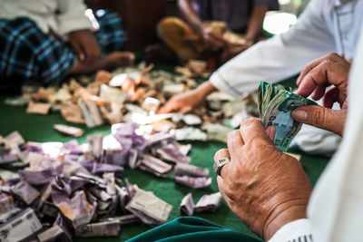 Midsection of people counting banknotes