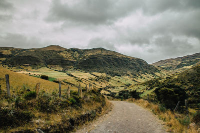 Road amidst field against sky