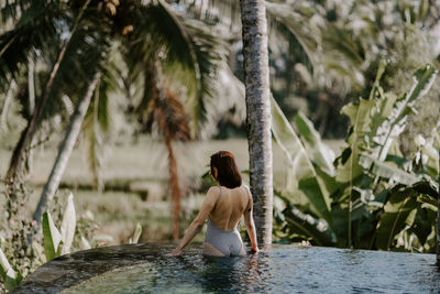 Full length of young woman sitting in water