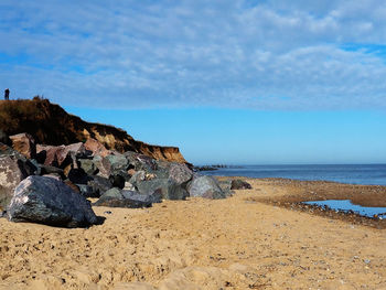 Rock formations on beach against sky