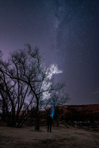 Rear view of man standing against sky at night