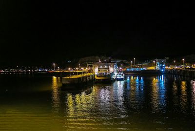 Boats in calm lake at night