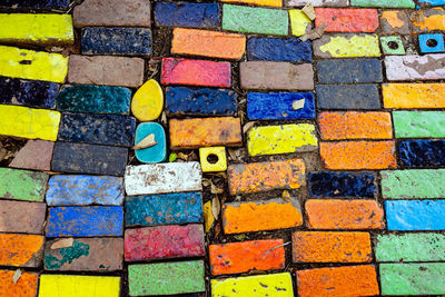 Top view on pieces of multicolored ceramic tiles decorated in garden. old pavement of tiles textured