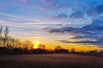 Scenic view of field against sky at sunset