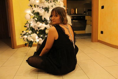Young woman sitting on floor at home