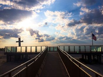 Bridge over sea against sky during sunset