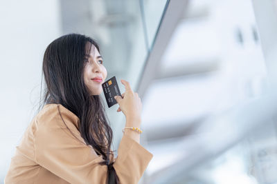 Side view of young woman using mobile phone