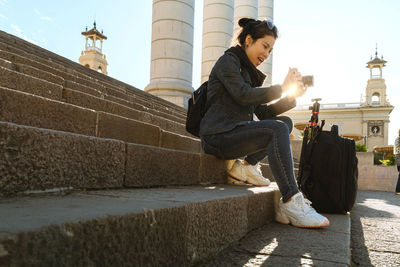 Side view of young woman sitting on staircase