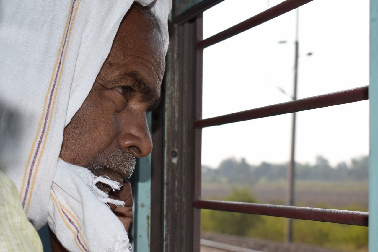 MAN LOOKING THROUGH WINDOW