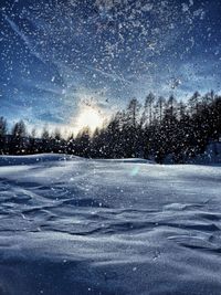 Snow covered landscape against blue sky at night