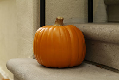 Assorted halloween decorations guard the front steps of a house. pumpkins on a porch.