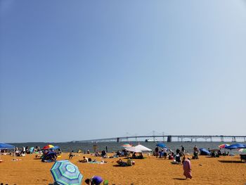 People on beach against clear sky