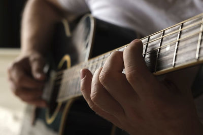 Midsection of man playing guitar