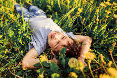 Cute little boy lying down on field and wide smiling