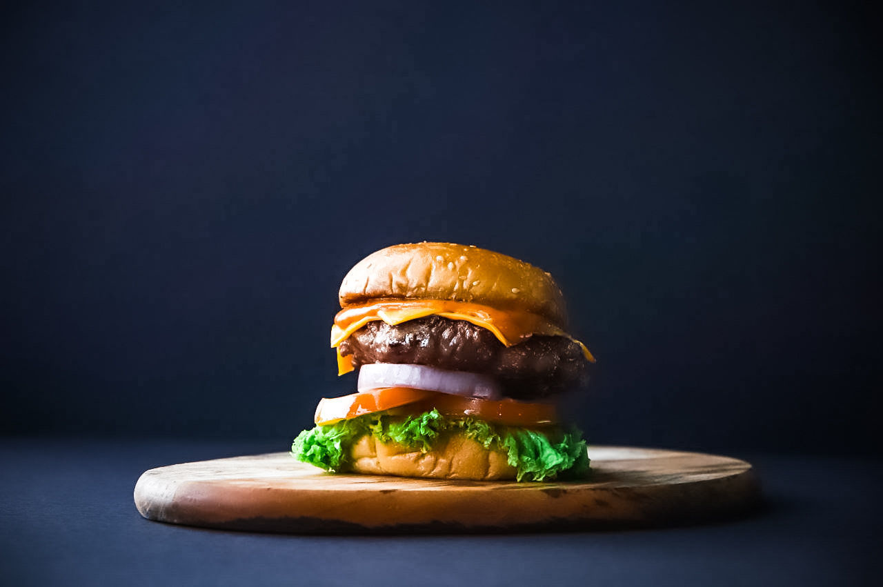 fast food, studio shot, food and drink, food, vegetable, burger, black background, unhealthy eating, ready-to-eat, sandwich, meat, hamburger, indoors, freshness, meal, close-up, bread, cheese, gray background, bun, cheeseburger, take out food