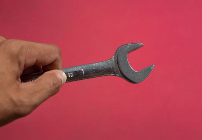 Close-up of man holding hand against red background