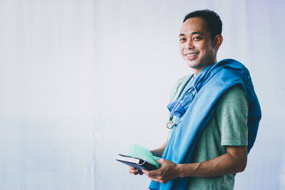 Portrait of smiling young man using smart phone