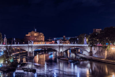 View of bridge over river at night