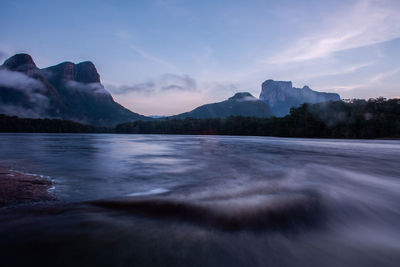 Longtime exposure of river in amazonia area at sunrise with typical tepui mountain in the background