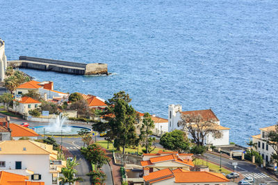High angle view of houses by sea against sky
