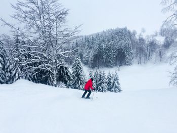 Woman on snowy landscape against sky