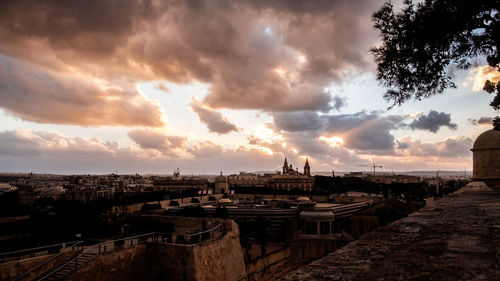 Panoramic view of buildings in city against sky at sunset