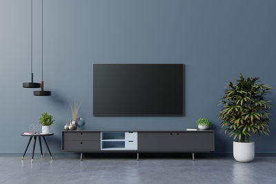 Led tv on the dark blue wall in living room,minimal design.3d rendering