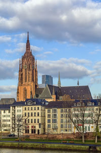 Buildings in city against cloudy sky