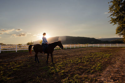 Full length of woman riding horse against sky