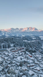 Aerial view of snow covered landscape against sky