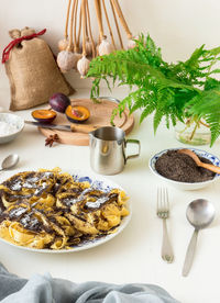 Low angle view of sweet pasta dessert, noodles with poppy seeds on white background table.